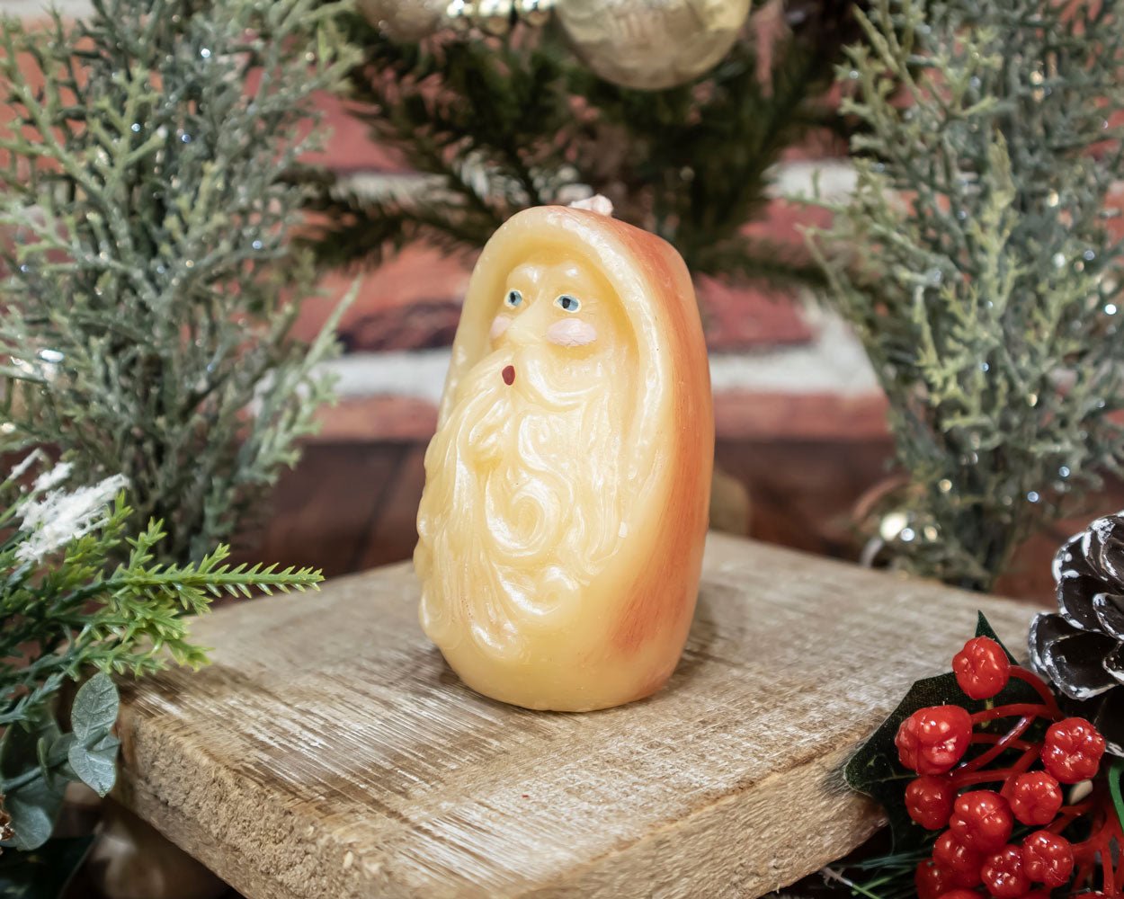 Painted Santa Head Beeswax Candle hand-crafted and hand-painted, showing detailed Santa face with holiday décor background