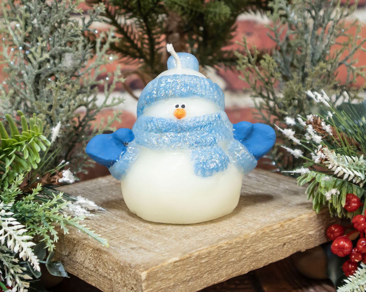 Close-up of hand-painted blue-hat glitter snowman beeswax candle with natural honey tone.