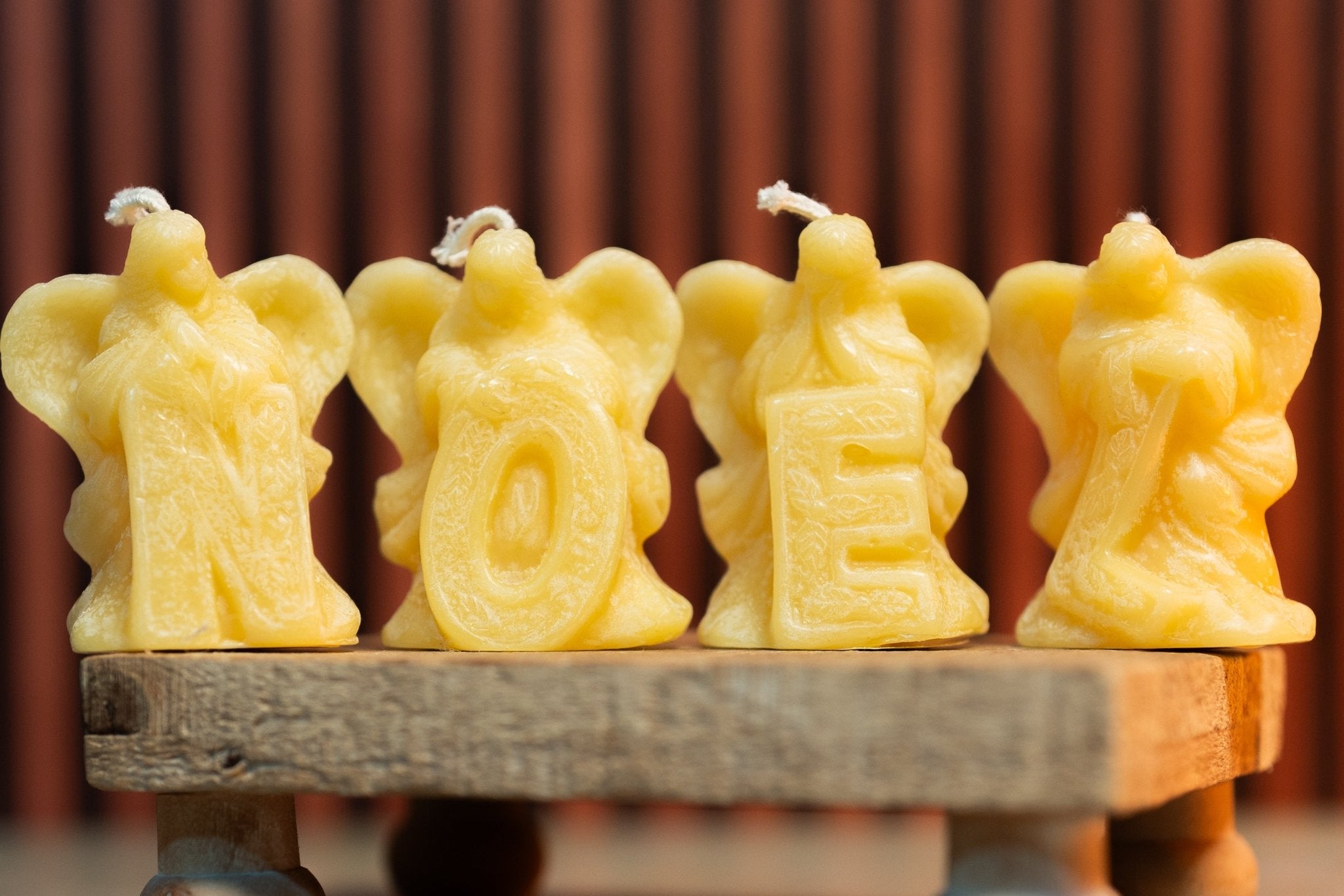Set of four angel molds spelling NOEL, detailed beeswax candle design.